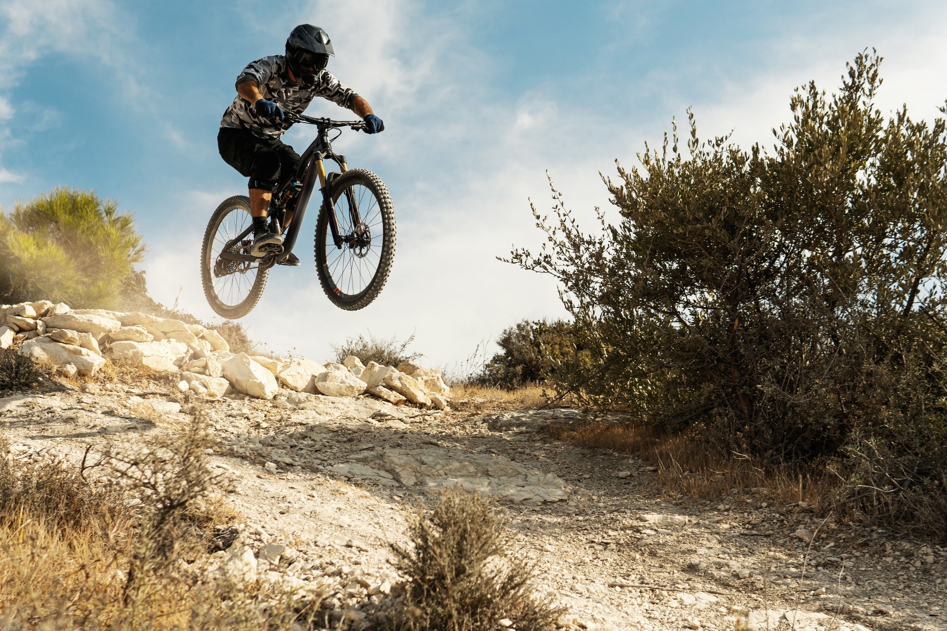 Professional bike rider jumping during downhill ride on his bicycle